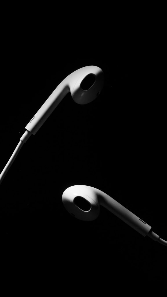 Earpods on black desk.